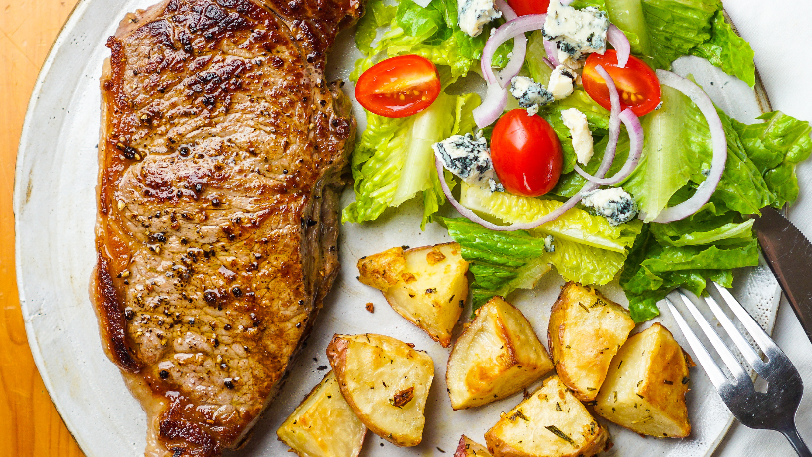 Delectable pork chop dinner with a side salad and roasted potatoes
